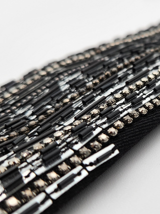 Close-up of bugle beading, seed beading, crystal rhinestones and sequins on black tie