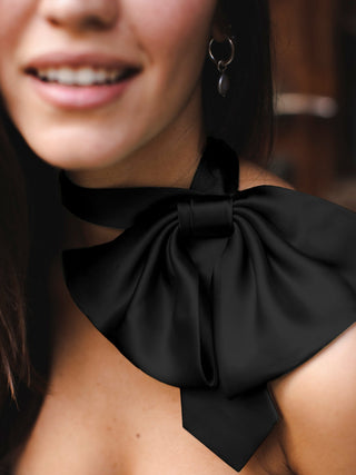 Model wearing black silk charmeuse bow tie off the shoulder