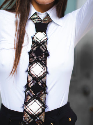Model wearing a beaded argyle tie over a white blouse