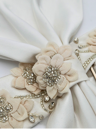 Closeup view of silk embroidered flowers and crystal beading on crystal jenny bow