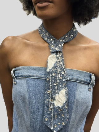 Model wearing a denim dress and a petite denim tie with frayed denim, sequins and crystal tassels.