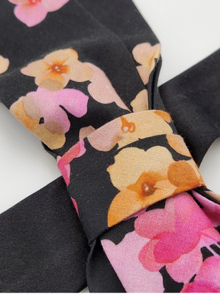 Floral-patterned fabric with pinks and golds on a black background