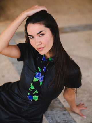 Model wearing a purple and green floral printed petite necktie over a black satin dress.