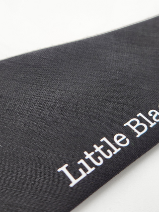 Close-up of black wool gabardine fabric and heat sealed letters