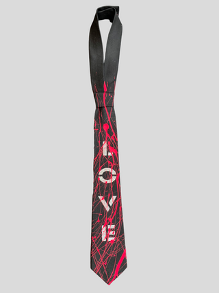Flat image of black classic necktie with the word Love painted in silver and red splatter paint