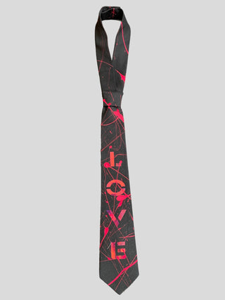 Flat image of black classic necktie with the word Love painted in red with red splatter paint