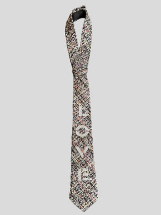 Flat image of metallic tweed necktie with the word love hand painted in silver