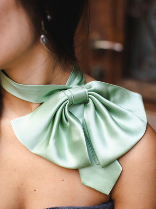 Model wearing sage green silk charmeuse bow off the shoulder