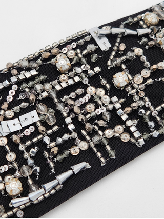 Details of crystal, sequin and glass beadwork on black background