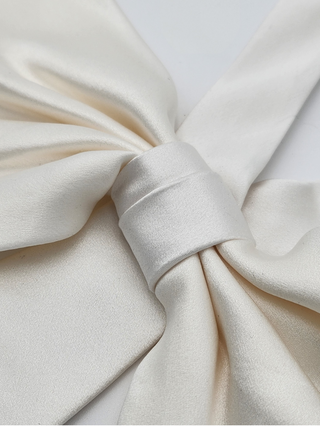 Closeup detail of white silk charmeuse bow