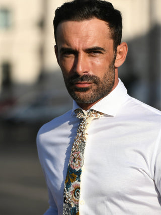 Male model wearing a crisp white shirt and a floral embroidered necktie 