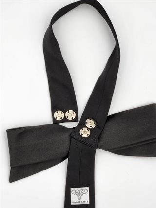 Back view of silver snaps and brand label on black bow tie
