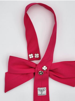 Back view of hot pink bowtie featuring silver snaps and brand label
