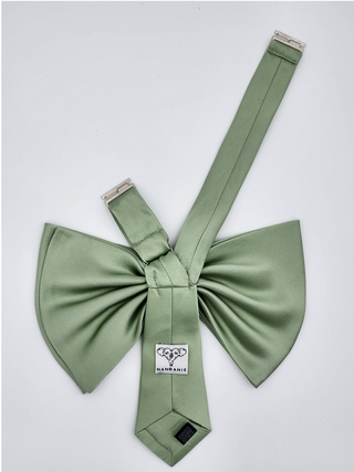 Back view of sage green silk charmeuse bow showing adjustable nickel clasp and brand label.